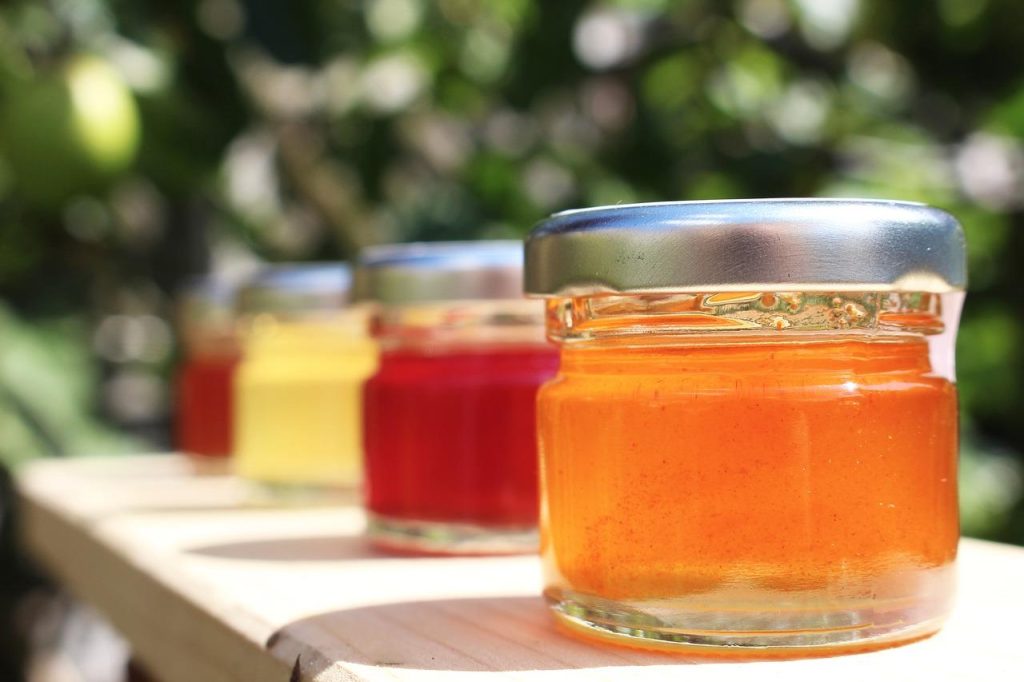 Rauwe honing in glazen pot, een natuurlijk product rechtstreeks uit de bijenkorf vol enzymen en antioxidanten